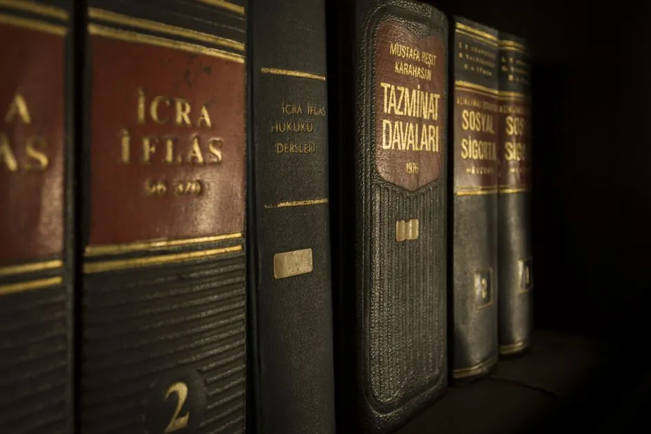Gros plan détaillé de livres de droit et de réglementation sur une étagère, mettant en avant l'éducation et la connaissance.